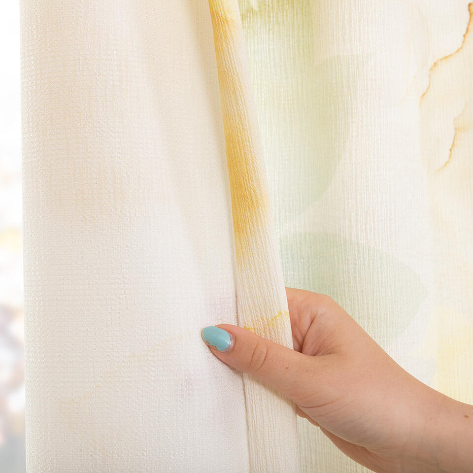 Lichtgekleurd basisdoek bedrukt met een vervaagde bloemprint in zachtgele, groen,- en blauwtinten.